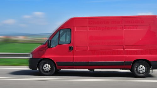 Image showing blurry (suggesting speed) van riding by road